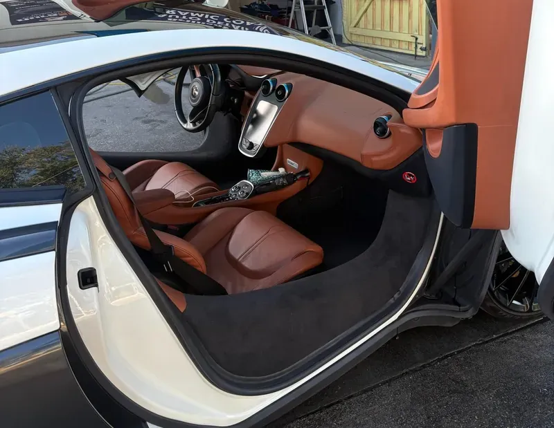 Interior of a McLaren with open scissor door after detail service